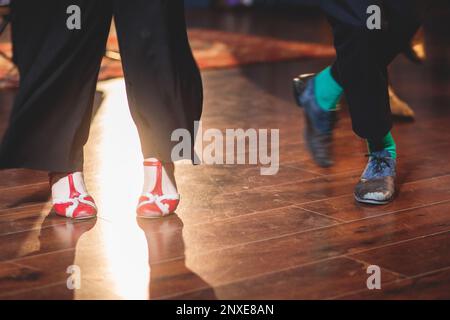 Scarpe da ballo di giovani coppie ballano balli jazz swing retrò su un locale da ballo con pavimento in legno, vista ravvicinata di una scarpa, femminile e maschile, lezioni di danza Foto Stock