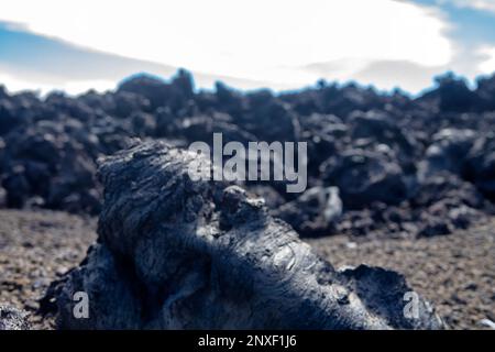 Varietà di forme di lava solidificata basaltica (clinker): hawaiano è il principale tipo di lava (aa-lava) eruttata dal mago. Lava viscosa contro il backgrou Foto Stock