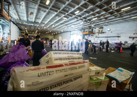 230126-N-KU796-1061 SOUTH CHINA SEA (26 GENNAIO 2023) USA I marinai della Marina organizzano la posta nella baia dell'hangar a bordo della portaerei USS Nimitz (CVN 68). Nimitz è presente negli Stati Uniti nel 7th Fleet e svolge operazioni di routine. 7th Fleet è la flotta statunitense La flotta numerata più grande della Marina e interagisce e opera regolarmente con alleati e partner per preservare una regione indomorosa e libera. Foto Stock