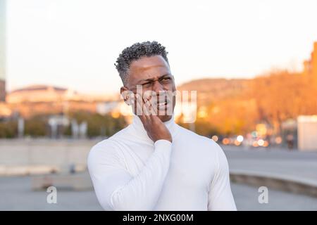 Ritratto di un uomo con pelle nera che lamenta dolore dentale Foto Stock