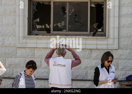 Attivisti israeliani e stranieri per la pace ispezionano i danni causati ai palestinesi a seguito dell'attacco dei coloni, nella città di Hawara, a sud di Nablus, nella Cisgiordania occupata. I coloni ebrei hanno attaccato la città di Hawara la notte del 26 febbraio, contro i palestinesi nella città di Hawara, e hanno bruciato case, automobili e proprietà dei palestinesi, dopo che due coloni israeliani sono stati uccisi in un attacco a fuoco in città. Foto Stock