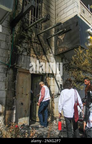 Attivisti israeliani e stranieri per la pace ispezionano i danni causati ai palestinesi a seguito dell'attacco dei coloni, nella città di Hawara, a sud di Nablus, nella Cisgiordania occupata. I coloni ebrei hanno attaccato la città di Hawara la notte del 26 febbraio, contro i palestinesi nella città di Hawara, e hanno bruciato case, automobili e proprietà dei palestinesi, dopo che due coloni israeliani sono stati uccisi in un attacco a fuoco in città. Foto Stock