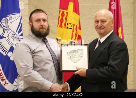 Dennis Weber (a sinistra), Rock Island Arsenal - Joint Manufacturing and Technology Center Machinist Graduate Apprentice Gennaio Classe di 2023, presenta una targa recante un disegno dell'Arsenal al ospite Lon Lukavsky, RIA-JMTC Machinist Graduate Apprentice Classe di 1978, in una cerimonia di laurea il 13 gennaio. Il programma di apprendistato del Dipartimento del lavoro ACCREDITATO RIA-JMTC si è laureato oltre 1.200 macchinisti di viaggio dal 1910 per garantire che la fabbrica abbia artigiani specializzati nella produzione di attrezzature di qualità per i caccia. Rock Island Arsenal - Joint Manufacturing and Technology Center sviluppa, manuf Foto Stock