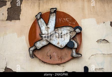 Uno scatto ravvicinato di un logo vintage di judo da combattimento con le intemperie su un vecchio muro usurato. Foto Stock