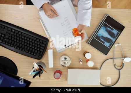 Medico che scrive la prescrizione per il paziente che soffre di polmonite Foto Stock