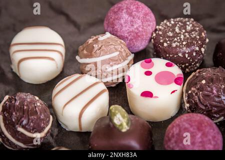 Praline al cioccolato tartufi e caramelle su fondo scuro. Foto Stock