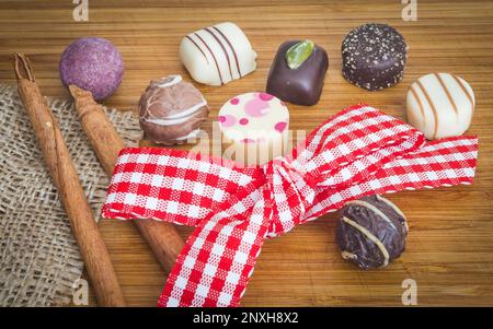 Praline al cioccolato con nastro di gingham a filo di colore rosso. Decorazione per il giorno di Pasqua. Foto Stock