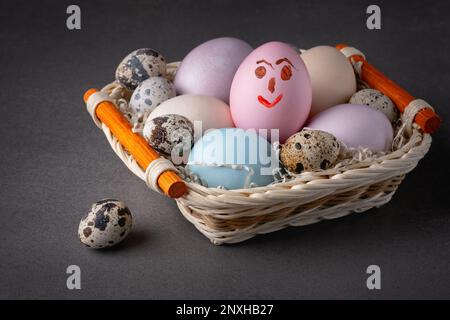 Cestino con uova di pasqua su sfondo grigio Foto Stock