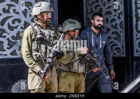 Nablus, Palestina. 01st Mar, 2023. I soldati israeliani costringono i palestinesi a chiudere i loro negozi nella città di Hawara, a sud di Nablus, nella Cisgiordania occupata. L'esercito israeliano continua a chiudere completamente la città di Hawara dopo che due coloni israeliani sono stati uccisi in un attacco di tiro in città. (Foto di Nasser Ishtayeh/SOPA Images/Sipa USA) Credit: Sipa USA/Alamy Live News Foto Stock