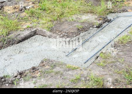 Riempimento della fondazione della striscia con cemento in cantiere. inizio della costruzione di una casa. Foto Stock