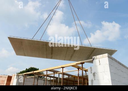 La lastra di pavimento prefabbricata vola attraverso l'aria di fronte bue cielo Foto Stock