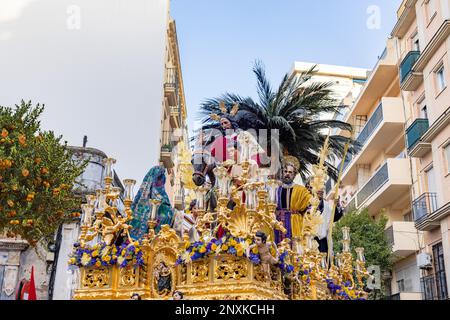 Cristo cavalcando un asino nel Trono o piattaforma della Confraternita della Borriquita, in processione per le strette stradine della città Foto Stock