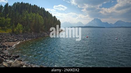 I Grand Teton sorgono nella foschia di Jackson Lake nel Parco Nazionale di Grand Teton Foto Stock