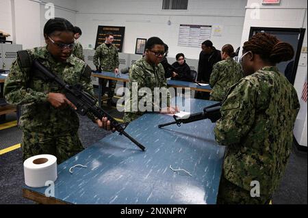 GREAT LAKES, Ill. (1 febbraio 2023) Seaman Apprentice Bridgette N. Burnette, al centro, legge le istruzioni tecniche come Seaman reclutare Shannon M. Grayesters, a sinistra, e Mija R. King, tutti i Surface Combat Systems Training Command studenti grandi Laghi, assemblare un M4 carbine al Gunner's Mate (GM) 'A' School. La GM “A” School offre ai marinai in via di adesione una formazione tecnica sulla manutenzione delle armi, l’elettricità, l’elettronica e il funzionamento dei sistemi di lancio e dei siluri. Foto Stock