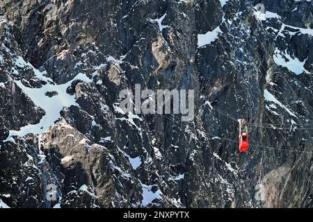 Funivia rossa di Lomnický štít che sale sulla scogliera degli alti Tatra sopra Skalnaté Pleso e Tatranská Lomnica in inverno Foto Stock