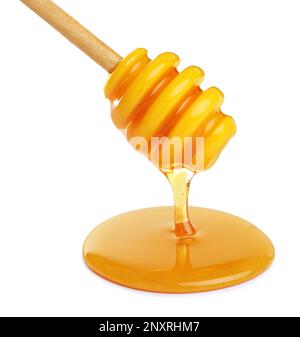Il miele sgocciola dal bilanciere su sfondo bianco Foto Stock