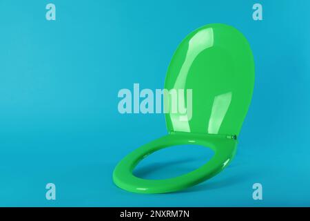 Nuovo sedile in plastica verde su sfondo azzurro, spazio per il testo Foto Stock