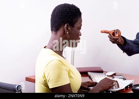 Vista ritagliata di un dito dell'uomo che indica una donna dipendente per incompetenza in ufficio. Foto Stock
