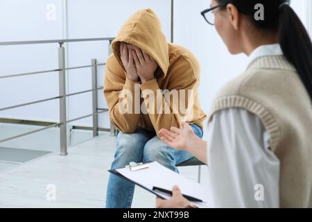 Psicoterapeuta che lavora con l'uomo tossicodipendente al chiuso Foto Stock