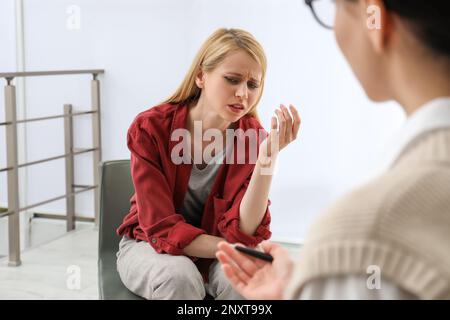 Psicoterapeuta che lavora con una giovane donna tossicodipendente in ambienti chiusi Foto Stock