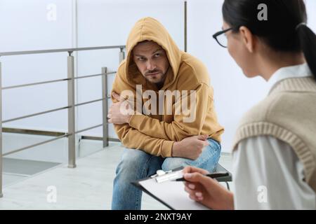 Psicoterapeuta che lavora con l'uomo tossicodipendente al chiuso Foto Stock