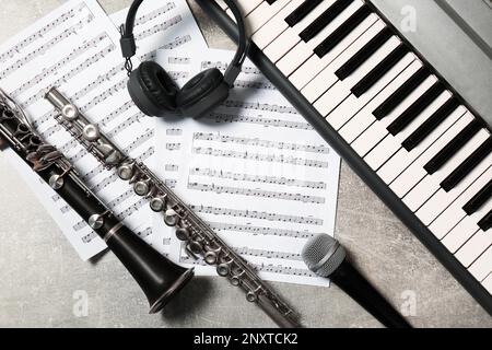 Composizione piatta con diversi strumenti musicali e microfono su sfondo grigio chiaro Foto Stock