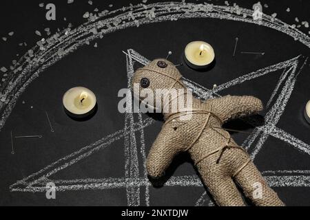 Bambola voodoo candele nere pentagramma e vecchi libri sul tavolo delle  streghe divinazione esoterica occulta e concetto di wicca voodoo mistico e  sfondo vintage