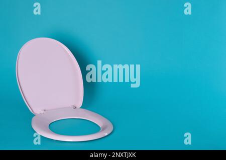 Nuovo sedile in plastica rosa su sfondo azzurro, spazio per il testo Foto Stock