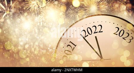 Orologio conteggio ultimi momenti per il nuovo 2022 anno e bellissimi fuochi d'artificio sullo sfondo, banner design Foto Stock