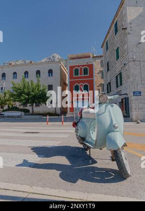 Vespa parcheggiata sul lungomare di Makarska Croazia Foto Stock