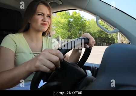 Donna emozionale in auto. Comportamento di guida aggressivo Foto Stock