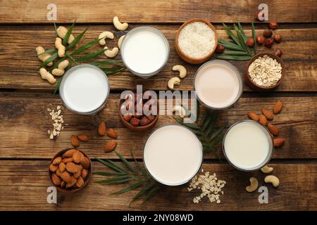 Diversi latte vegano e ingredienti su tavola di legno, piatto Foto Stock