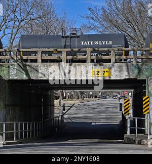 EMPORIA, KANSAS - 1 MARZO 2023Burlington Northern Santa Fe (BNSF) treno che trasporta una serie di carri armati riempiti con le teste di sciroppo di mais a est al cavalcavia di strada del Congresso che è in bisogno di riparazione di infrastruttura come le pareti di cemento stanno fallendo. Credito: Mark Reinstein/MediaPunch Foto Stock