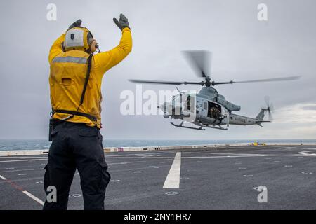 MARE DELLA CINA DEL SUD (4 GENNAIO 2023) - STATI UNITI Navy Aviation Boatswain’s Mate (handler) Tyler Perry, assegnato alla banchina di trasporto anfibio USS Anchorage (LPD 23), segnala agli Stati Uniti Marine Corps UH-1Y piloti di Venom con Marine Medium Tiltrotor Squadron (VMM) 362 (Rein.), 13th Marine Expeditionary Unit, al decollo dall'Anchorage, 4 gennaio. La mobilità e la sostenibilità fornite dalle piattaforme anfibie consentono al team Navy-Marine Corps di ampliare la portata delle nostre capacità. 7th Fleet è la flotta statunitense La flotta numerata più grande della Marina, distribuita in avanti, interagisce e opera regolarmente con alleati e partner Foto Stock