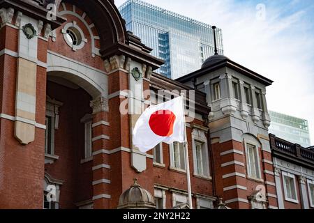 Tokyo, Giappone. 6th Feb, 2023. Una bandiera giapponese vola (bandiera hinomaru, bandiera giapponese) fuori dalla stazione di Tokyo lato Marunouchi in una giornata di sole, servendo pendolari e turisti sia su JR East e JR Central Intercity Trains.Tokyo Station (Æ±äº¬é§…) È uno storico hub di trasporto in Giappone, che serve come terminal per shinkansen e treni locali. E' anche una destinazione per lo shopping e per i ristoranti, con ristoranti, boutique e un hotel nel suo edificio principale in mattoni rinnovato. L'amministrazione di Kishida e' destinata a svelare nuove politiche sull'immigrazione e la popolazione date le lotte economiche del Giappone con un declino Foto Stock