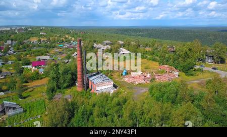 Vista dall'alto delle rovine della vecchia fabbrica nel villaggio. Fermo. Crollato costruzione di fabbrica di mattoni nel villaggio in estate. Rovine di vecchia fabbrica di mattoni nel villaggio. Foto Stock