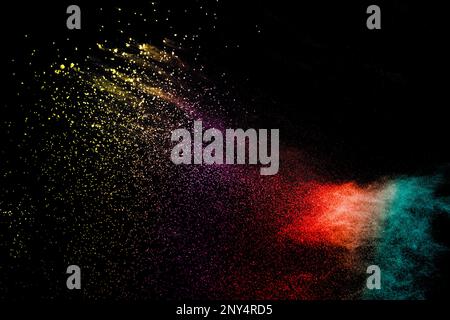 Esplosione di coloratissimi Holi polvere su sfondo nero. Colori brillanti di particelle di polvere textured background. Foto Stock