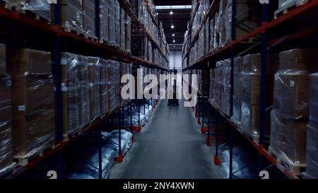 Enormi scaffali situati l'uno vicino all'altro. Creativo. Armadietti lunghi con ripiani con pacchi che sono imballati ermeticamente. Riprese in 4K di alta qualità Foto Stock