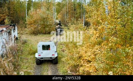 Cammina sugli scooter lungo uno stretto sentiero. Campi e foreste di clip.Green con quad in giro durante il periodo autunnale. FullHD di alta qualità Foto Stock