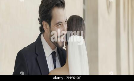 Abbracciare la sposa e lo sposo. Azione. Una coppia sorridente felice che si basa su un appuntamento all'aperto. Riprese in 4K di alta qualità Foto Stock