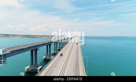 Vista dall'alto del bellissimo ponte sul mare blu. Scatto. Lunga autostrada con ponte sull'acqua blu. Ponte attraverso stretto tra le isole con bella stagione Foto Stock