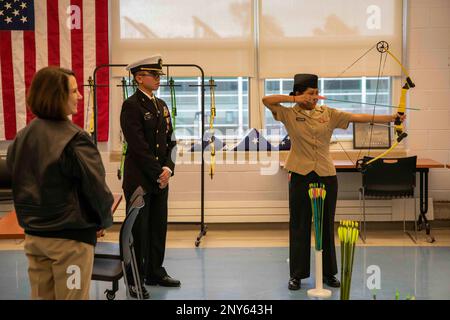 CHICAGO (20 gennaio 2023) Rear ADM. Jennifer Couture, comandante, Naval Service Training Command (NSTC) (a sinistra), guarda una dimostrazione di tiro con l'arco data da un cadetto di addestramento di George Westinghouse College Prep High School Navy Junior Reserve Officers (NJROTC) (a destra) come parte di una visita di NJROTC sito, 20 gennaio. Couture e il suo staff NSTC, con sede presso la Naval Station Great Lakes, Ill., supervisionano il programma NJROTC, composto da più di 600 unità in tutti gli Stati Uniti. Foto Stock