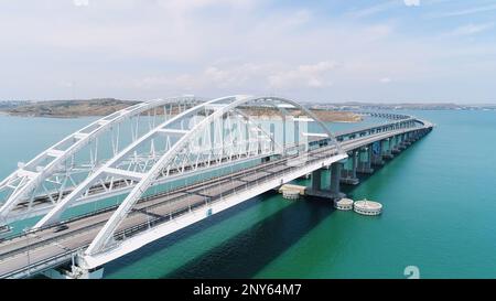 Vista dall'alto del bellissimo ponte sul mare blu. Scatto. Lunga autostrada con ponte sull'acqua blu. Ponte attraverso stretto tra le isole con bella stagione Foto Stock