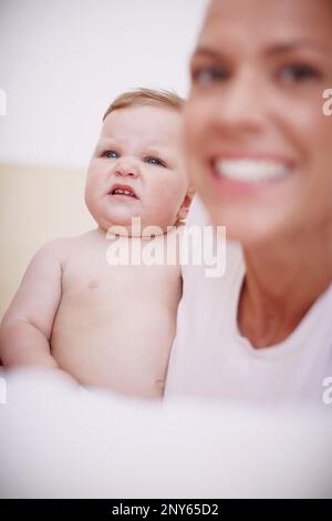 Ha le espressioni facciali più belle. una bambina che fa un volto mentre si siede accanto a sua madre. Foto Stock