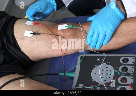 Elettromiografia EMG e potenziale evocato somatosensoriale PEV delle estremità inferiori, test neurofisiologico applica stimoli elettrici in prossimità dei nervi Foto Stock