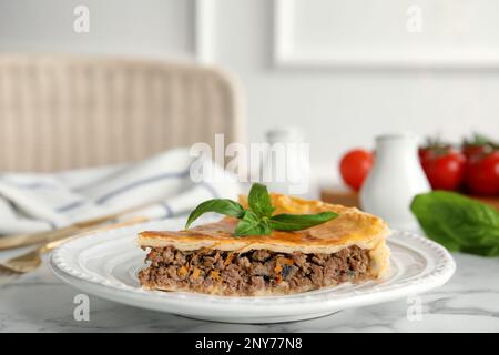 Pezzo di deliziosa torta con carne macinata sul tavolo al coperto Foto Stock