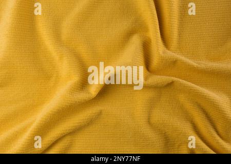 Asciugamano da spiaggia giallo stropicciato come sfondo, vista dall'alto Foto Stock