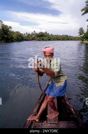 Un uomo che rema, spingendo la barca, Backwaters del Kerala, India del sud, India, Asia Foto Stock