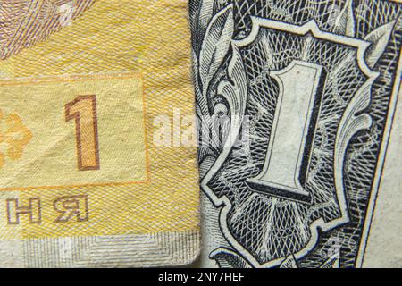 Un hryvnia Ucraina ed un dollaro americano come macro di fondo Foto Stock