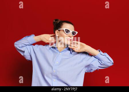 Ritratto in vita di una donna adulta vestita alla moda con pelle sana che solleva le mani e si allunga Foto Stock
